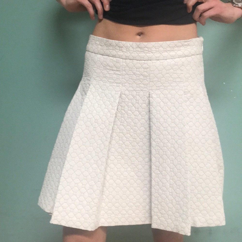 A line pleated ivory mid length skirt.